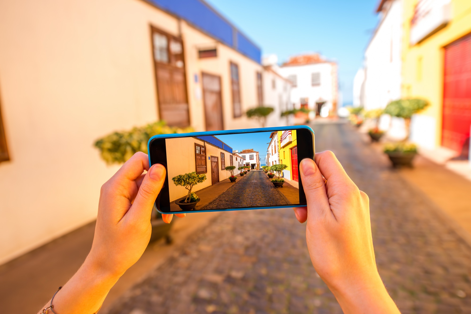 Traveler photographing a colorful street with a smartphone