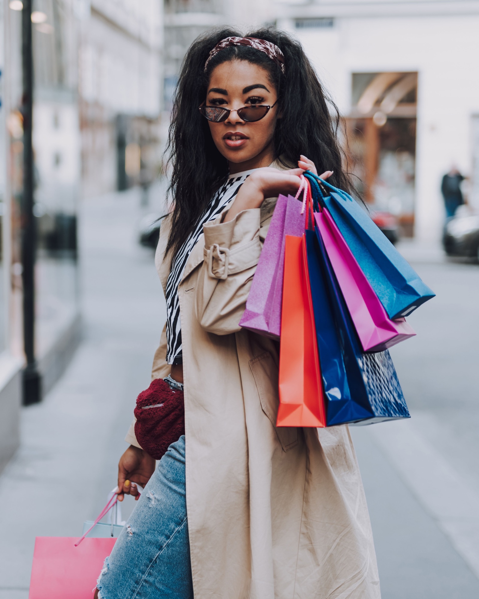 Woman carrying colorful shopping bags on a city street