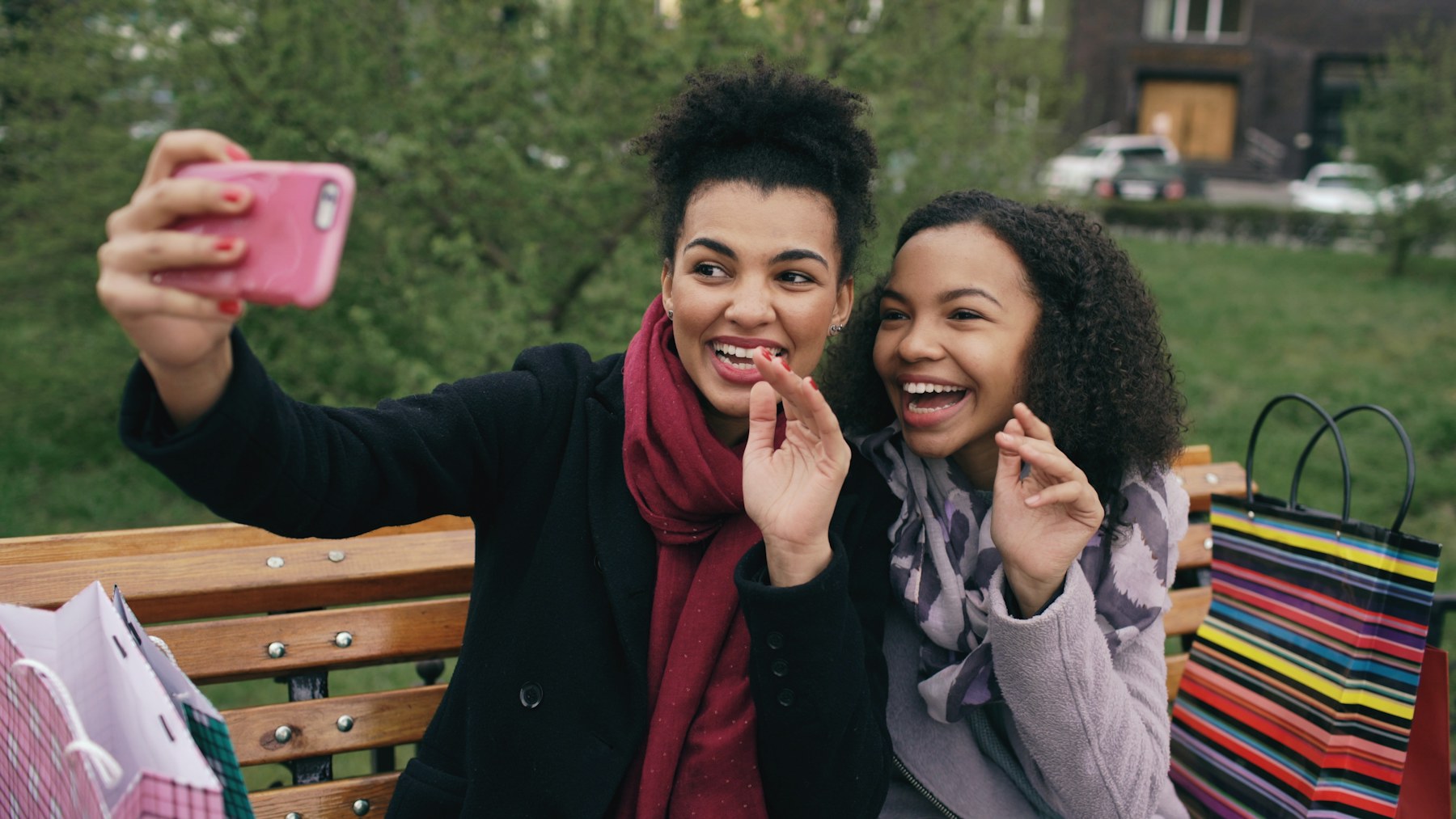 Two women taking a selfie on a park bench