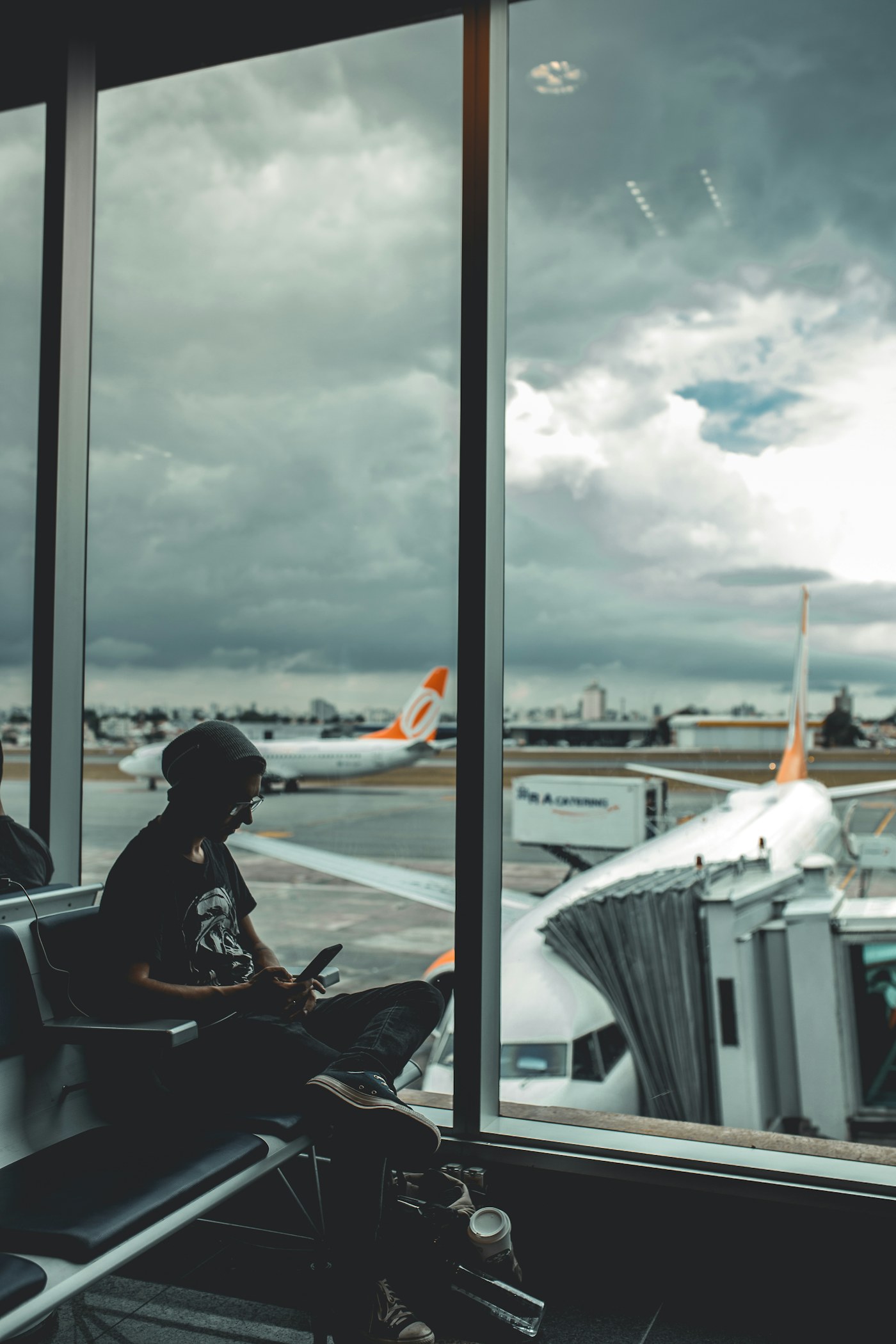 A traveler browsing his phone at an airport gate