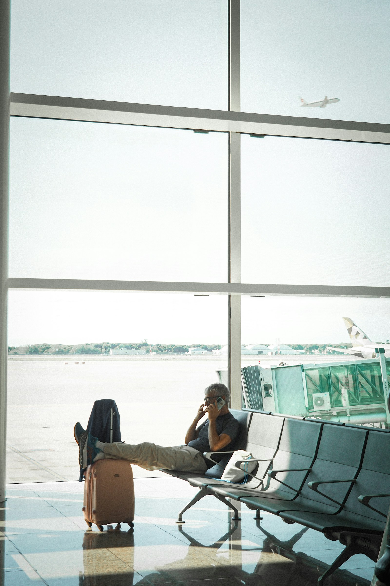 A traveler on the phone in an airport waiting area